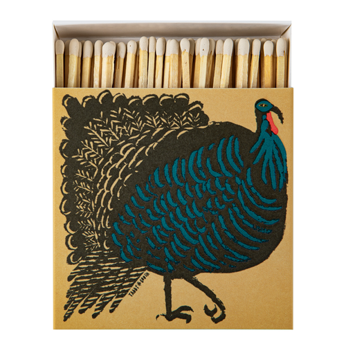 An Archivist matchbox package with a illustrated turkey on a tan background and a row of wooden matches visible in the open top. The turkey artwork is black with bright blue and small red accents.