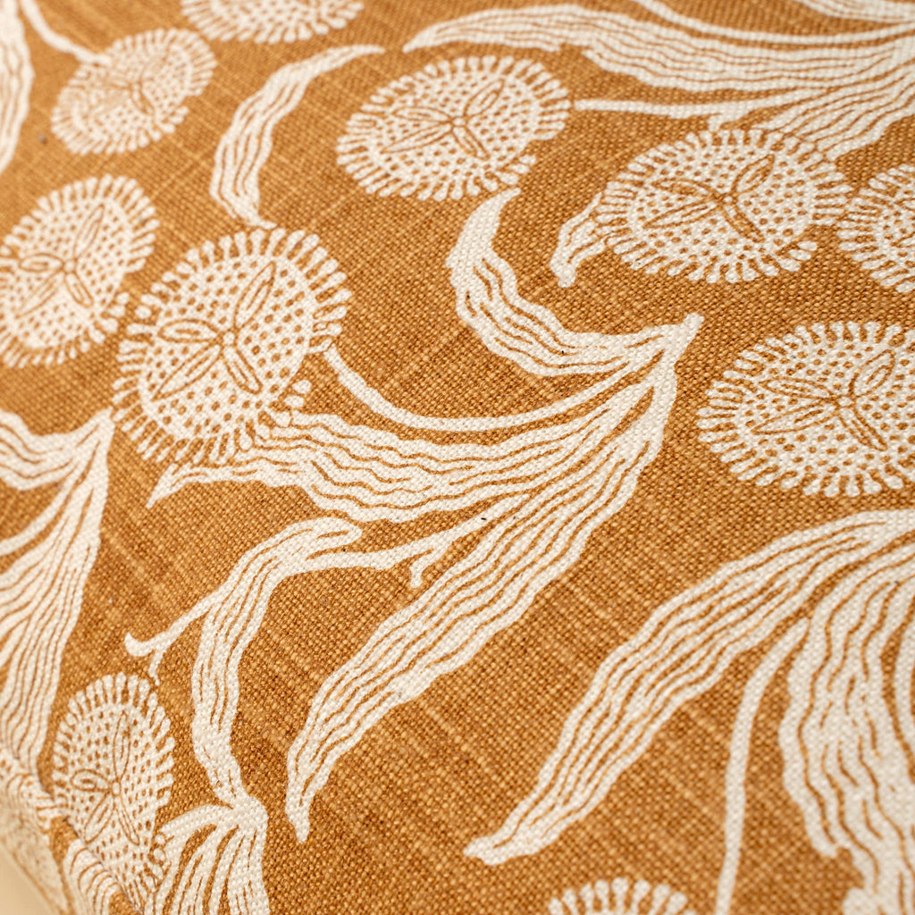 Close-up of fabric with beige floral pattern on a brown background