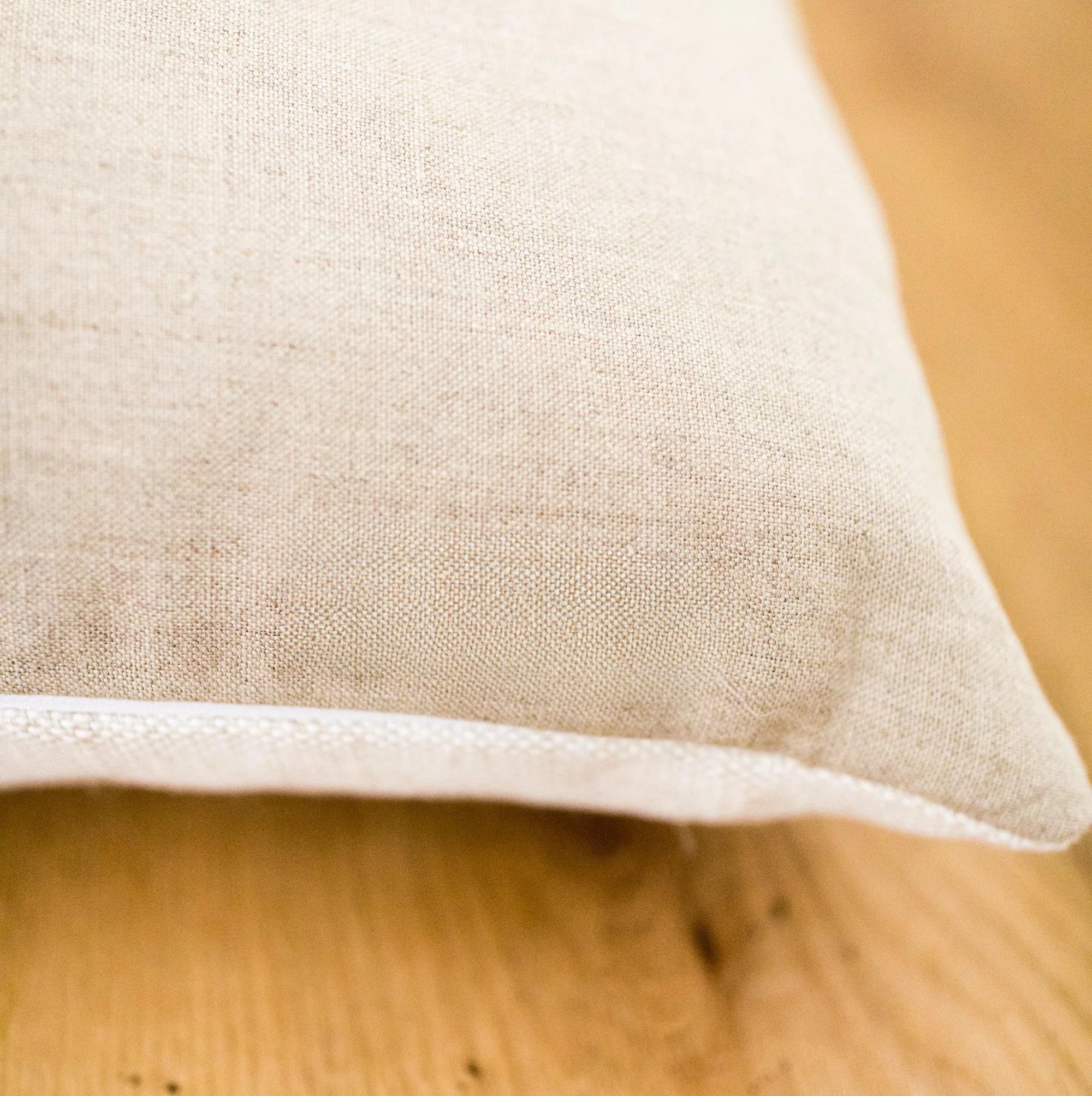 Close-up of a natural linen fabric pillow back on a wooden surface