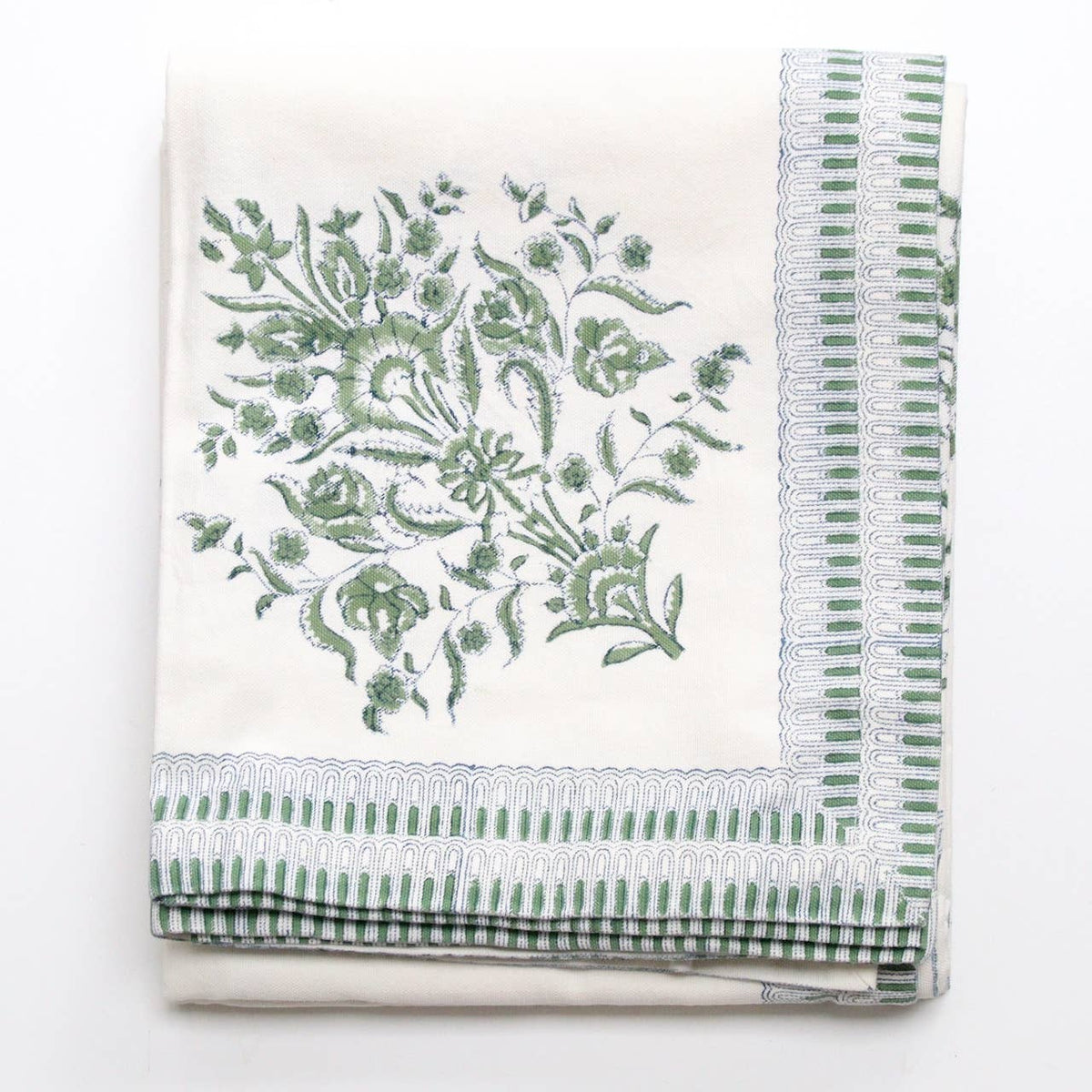 Green and white block print tablecloth folded on a white background