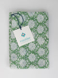 Green and white Floral block print dish towel or tea towel with a Rozablue tag on a light gray background