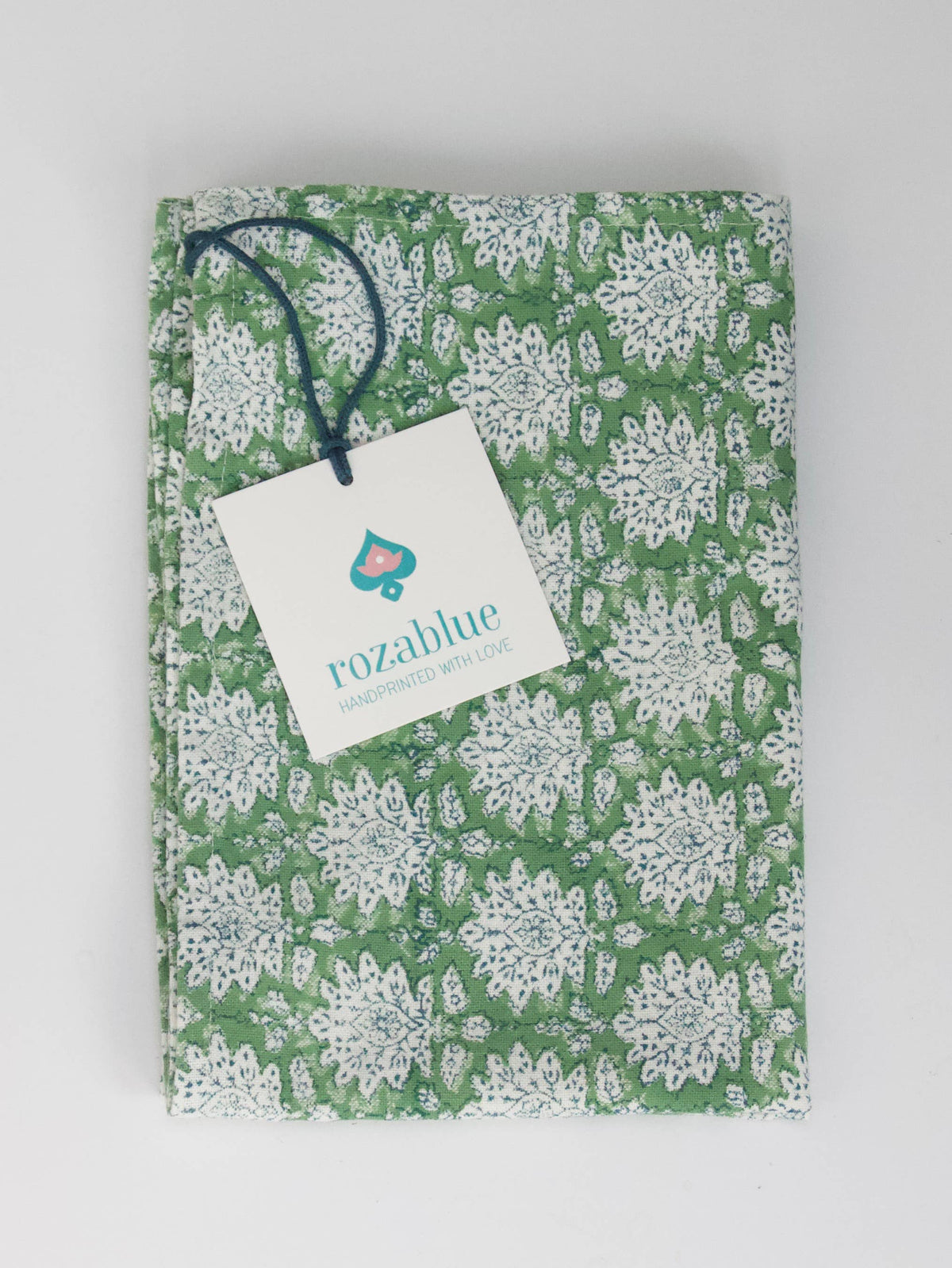 Green and white Floral block print dish towel or tea towel with a Rozablue tag on a light gray background