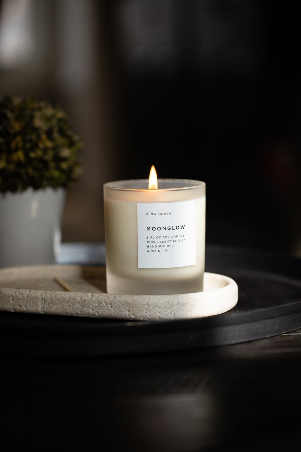 Slow North Candle labeled 'Moonglow' on a stone tray with a dark background