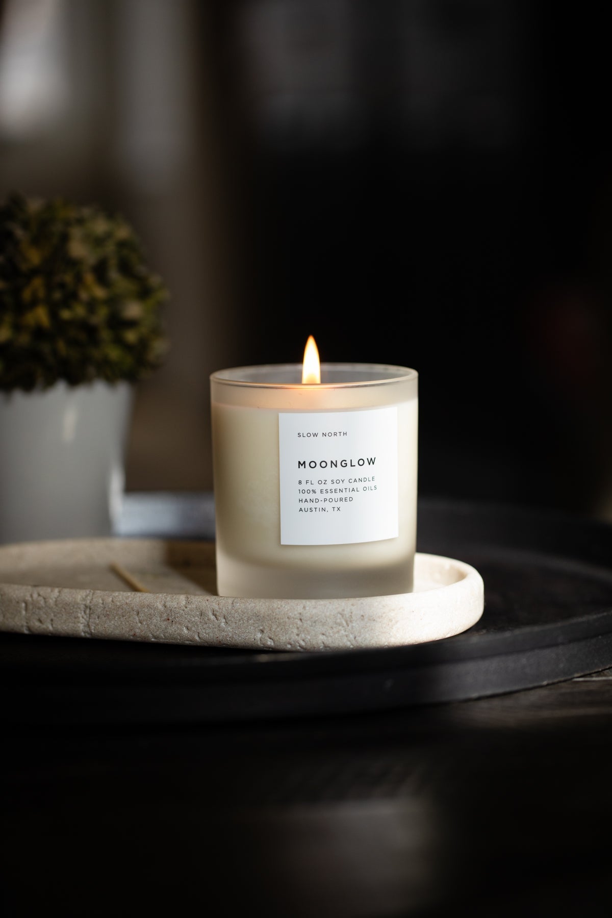 Slow North Candle labeled 'Moonglow' on a stone tray with a dark background
