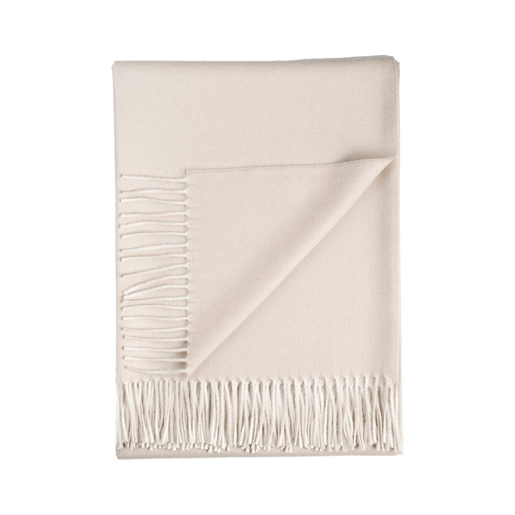 White alpaca blanket with fringes on a white background