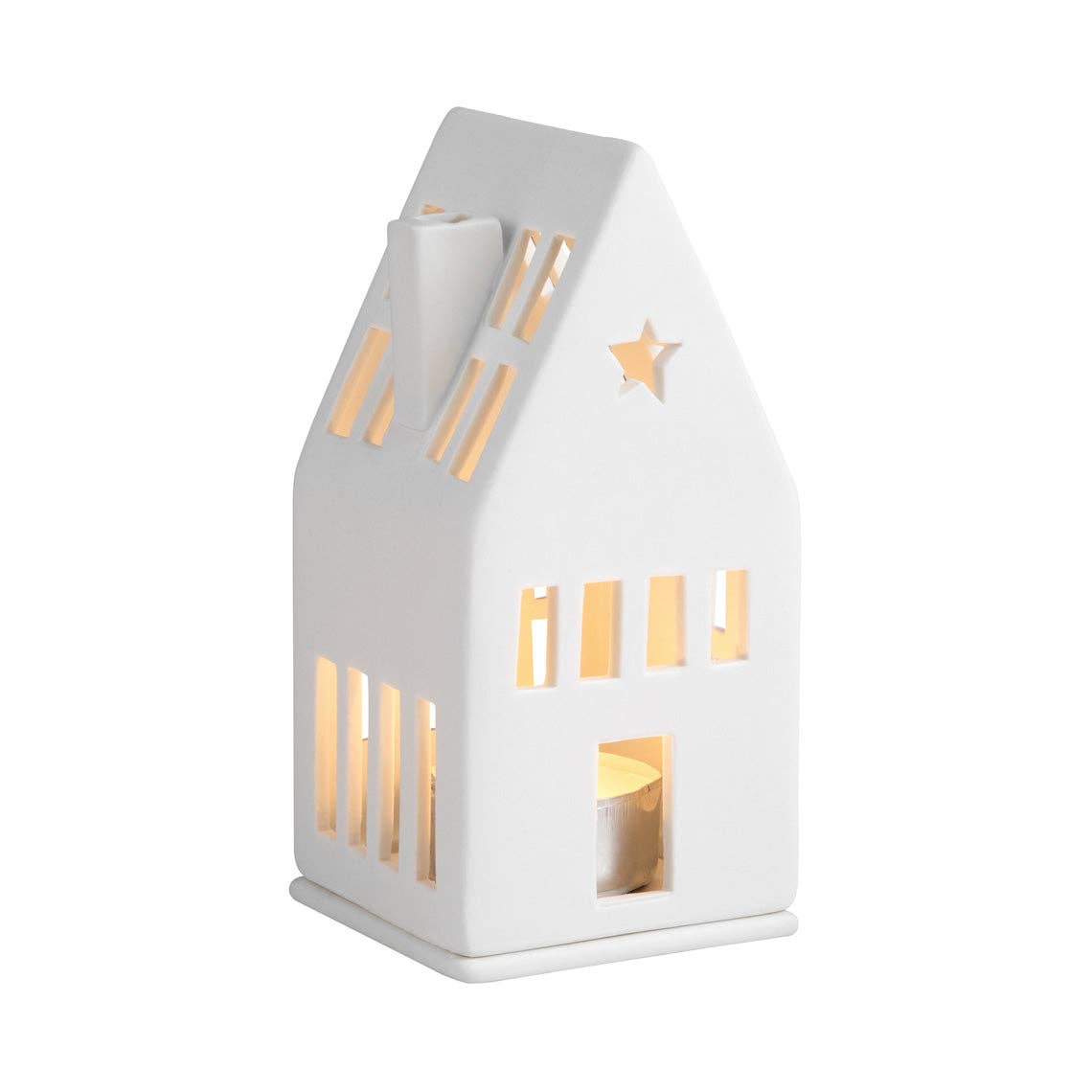 A white house-shaped ceramic tea light holder with cutout windows and a star detail, glowing warmly from an internal tea light, on a solid white background.